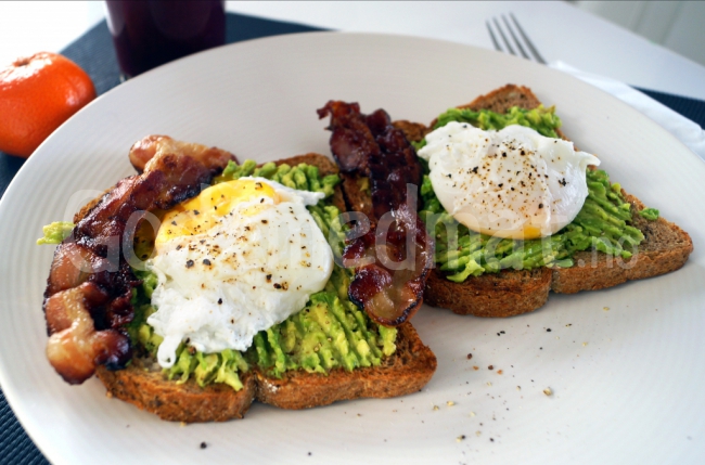 Brødskive med avokado, posjerte egg og sprøstekt bacon